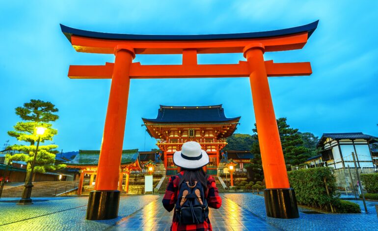 woman traveler with backpack fushimi inari taisha shrine kyoto japan 2